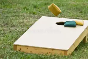 cornhole bag toss game flight towards hole board 44608785
